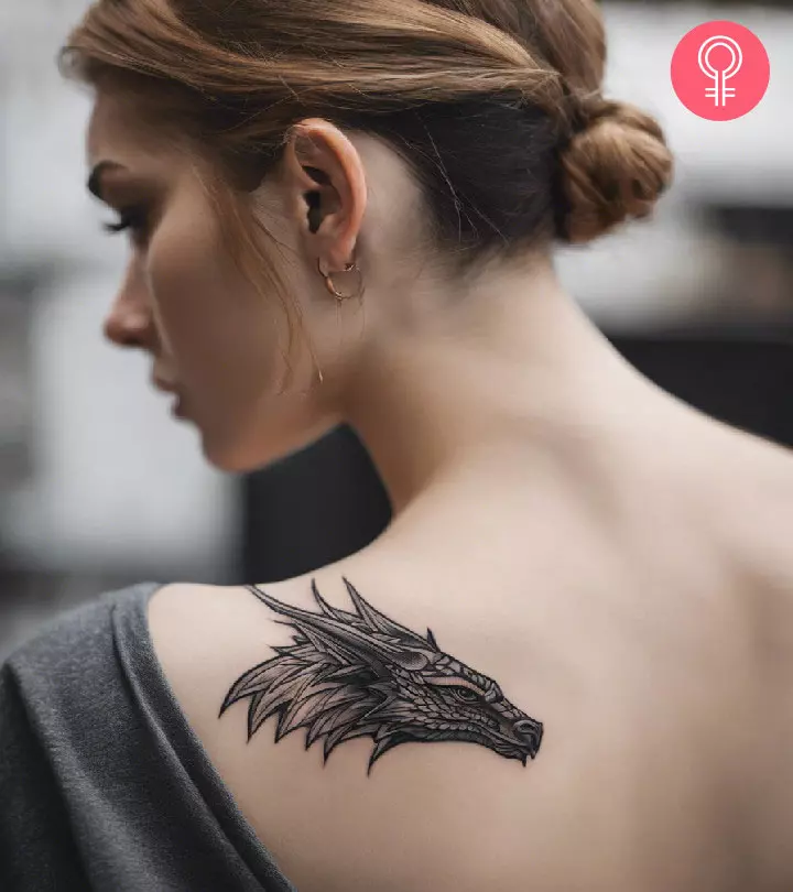 A woman with a dragon head tattoo on the shoulder