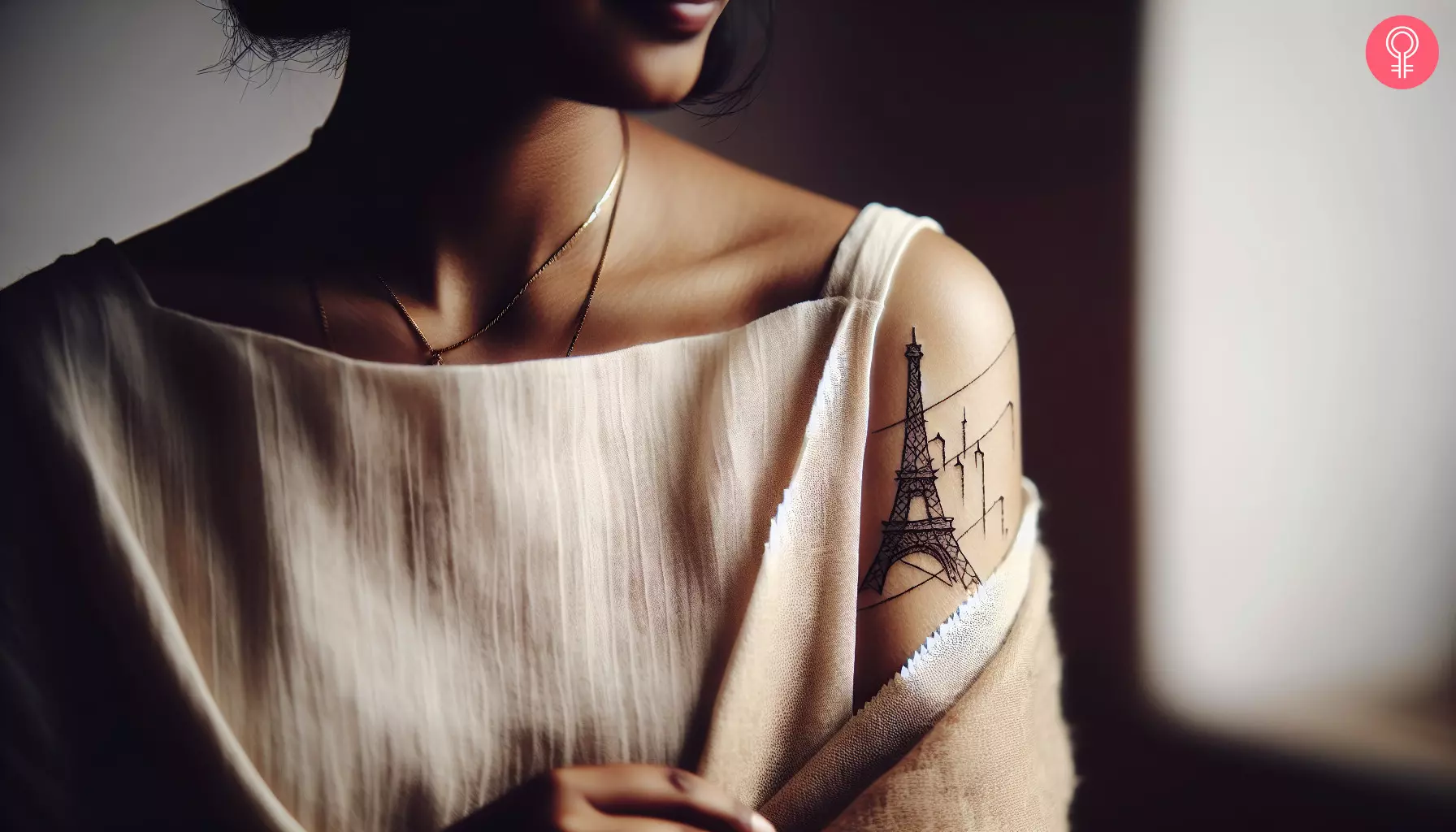 A woman with a fine line Eiffel Tower tattoo on her upper arm