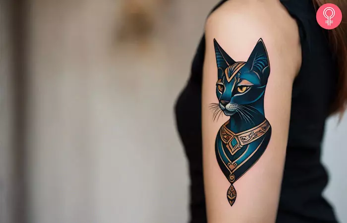 A woman with a neo traditional bastet tattoo on her upper arm