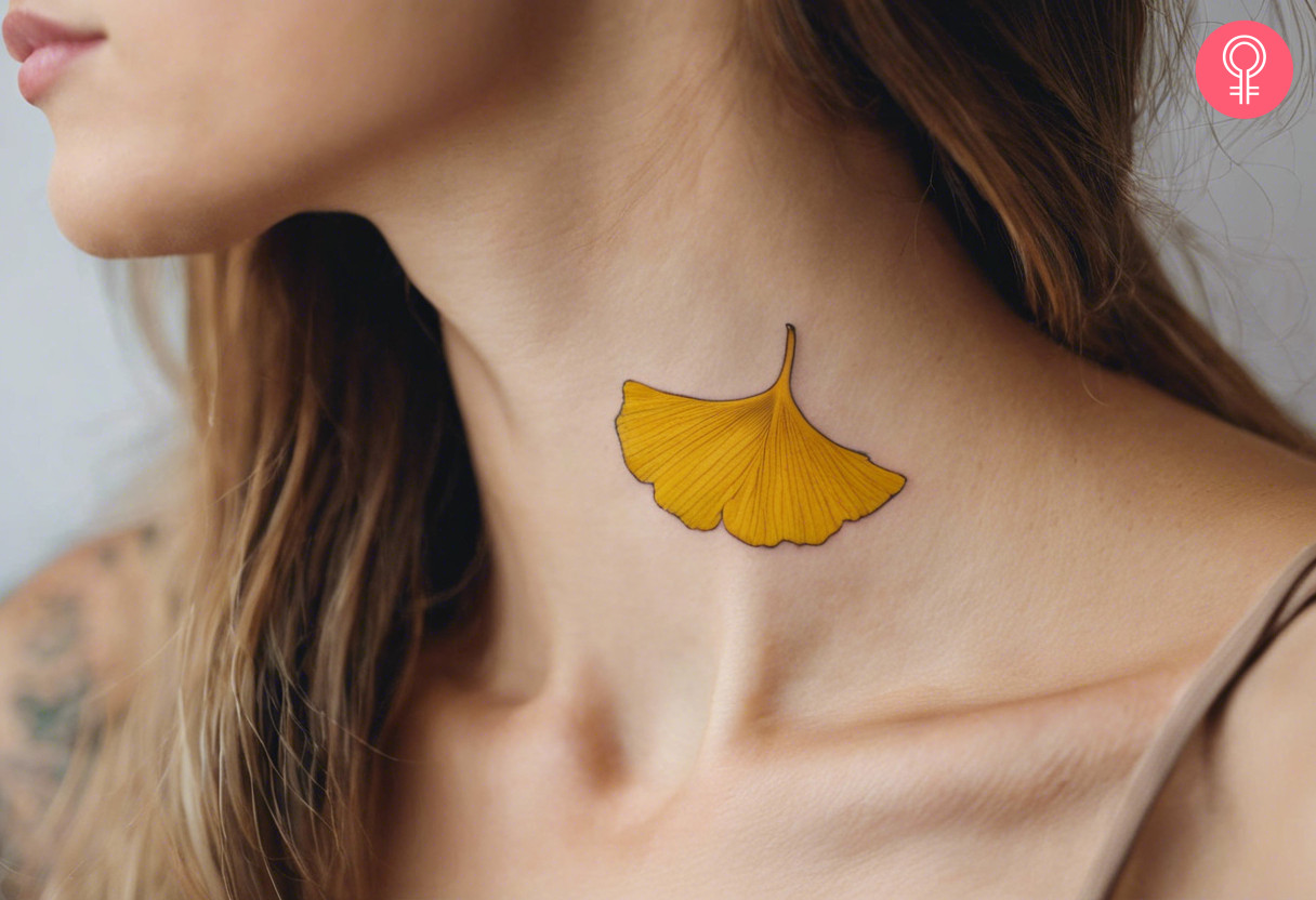 A yellow Ginkgo leaf tattoo on the side of the neck