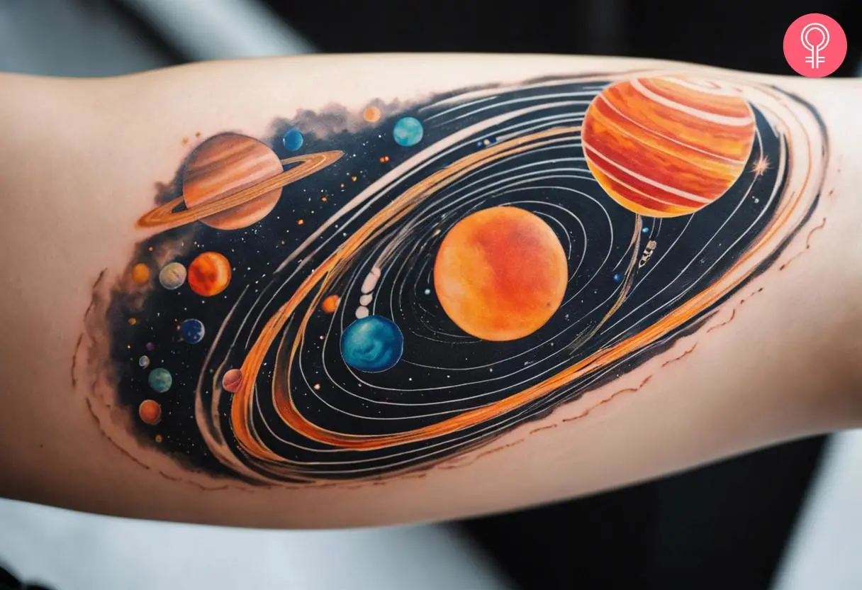 A woman with an abstract solar system tattoo design on her bicep