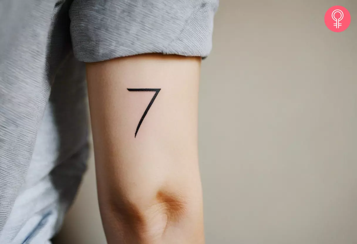 A back of arm tattoo of the number seven above the elbow