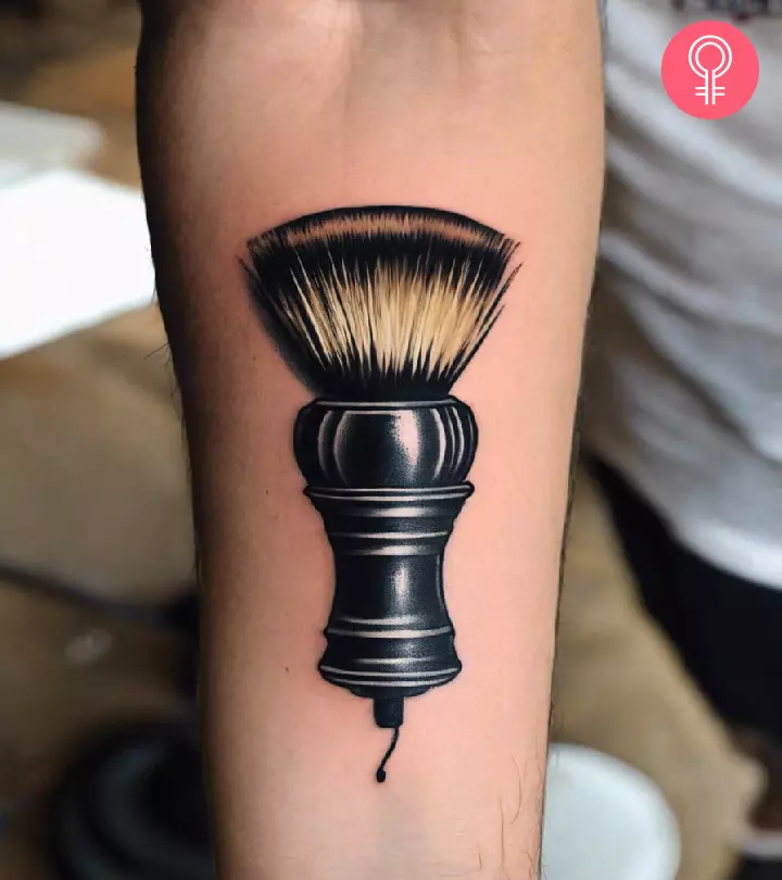 A realistic shaving brush tattoo on the forearm
