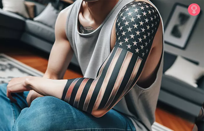 A man with a black and white tattoo of the American flag on his arm