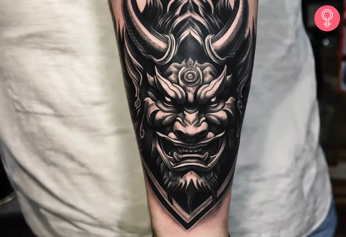 Black and gray Japanese Oni demon head tattoo on the forearm