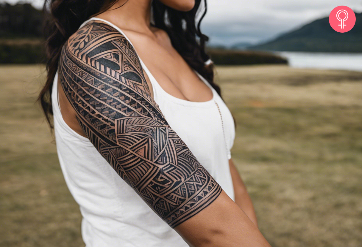 Black illustrative maori tattoo on the upper arm of a woman
