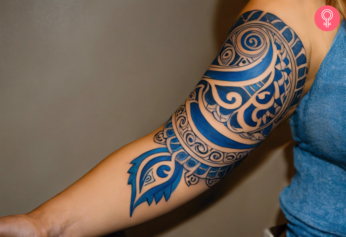 Blue maori tattoo on the upper arm of a woman