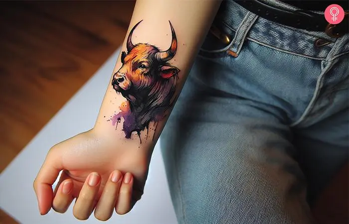 A woman with a watercolor style bull tattoo on the wrist