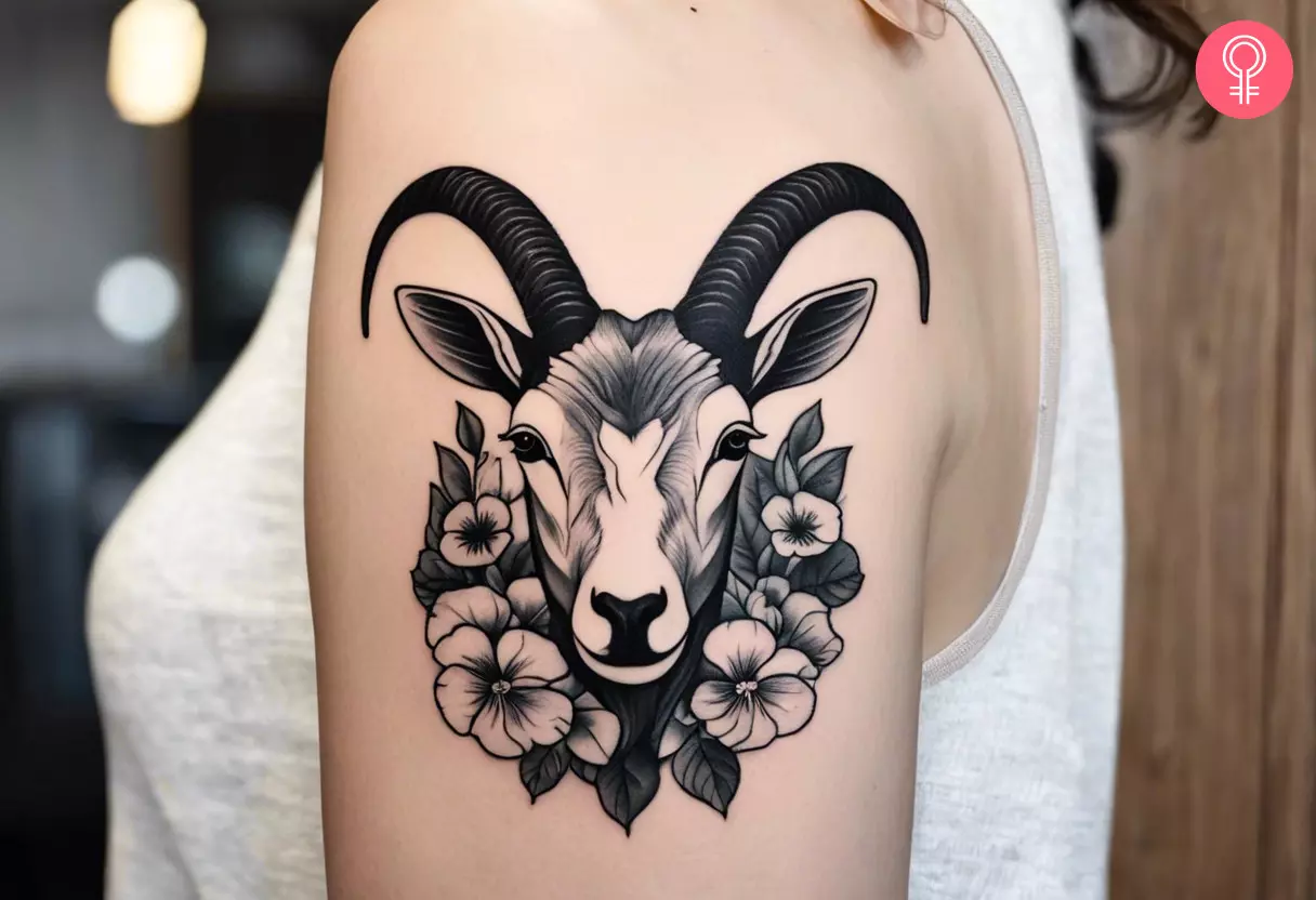 A black and white zodiac Capricorn pansy tattoo on the upper arm