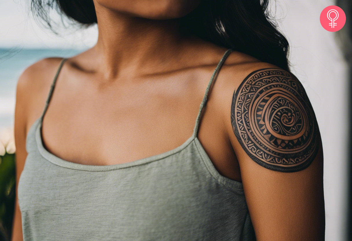 Circular maori tattoo design on the upper arm of a woman