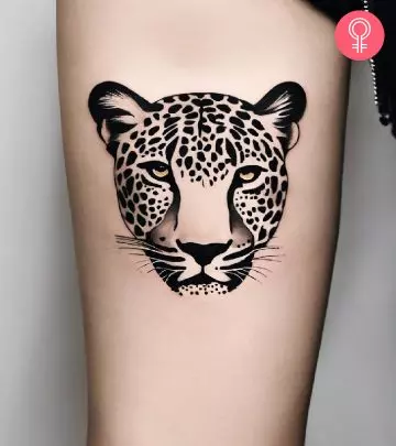 A woman with a leopard print heart tattoo on the upper arm