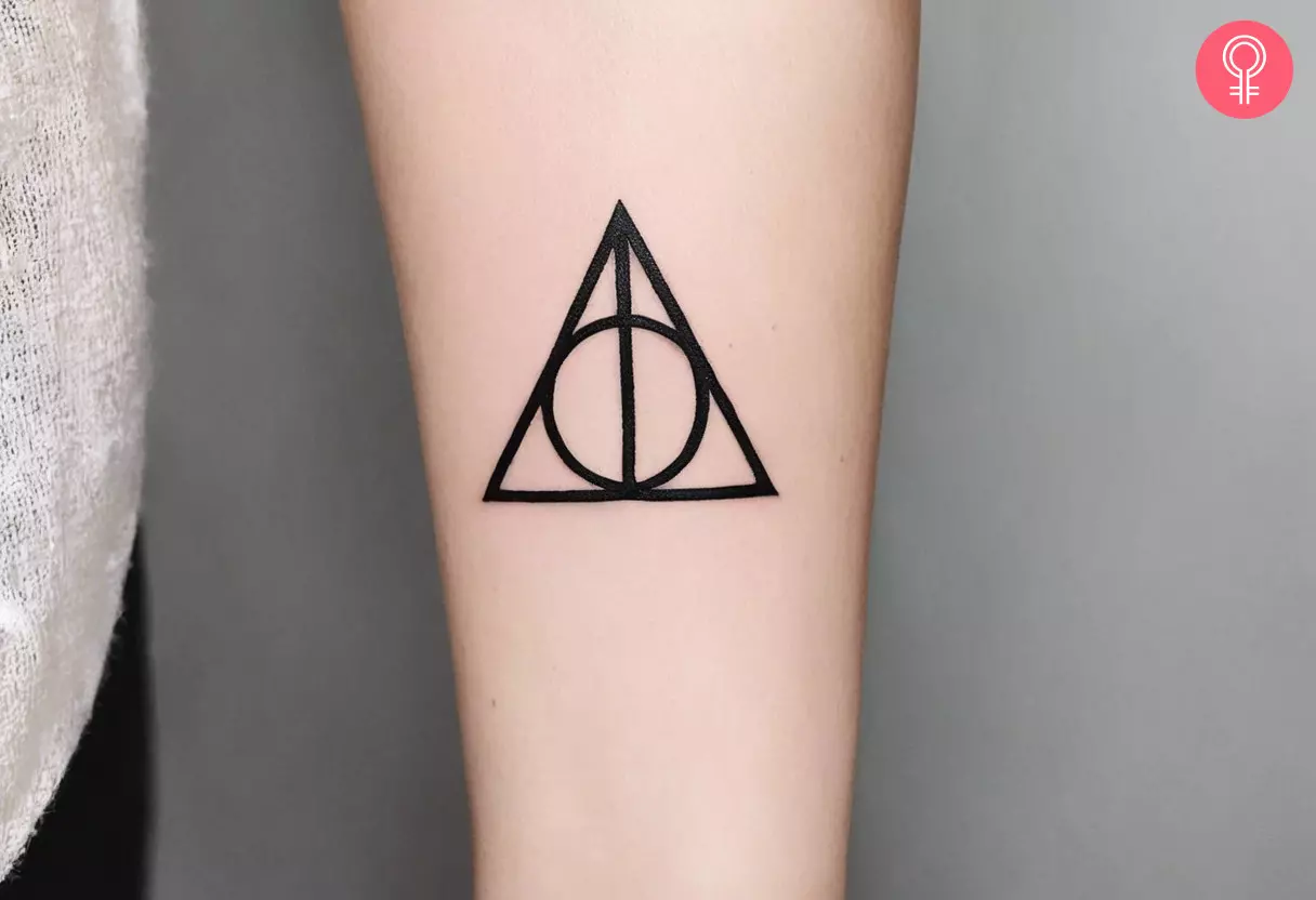 A woman with a Deathly Hallows tattoo on her forearm