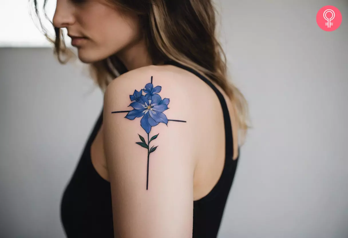 Woman with a delphinium cross tattoo on the upper arm