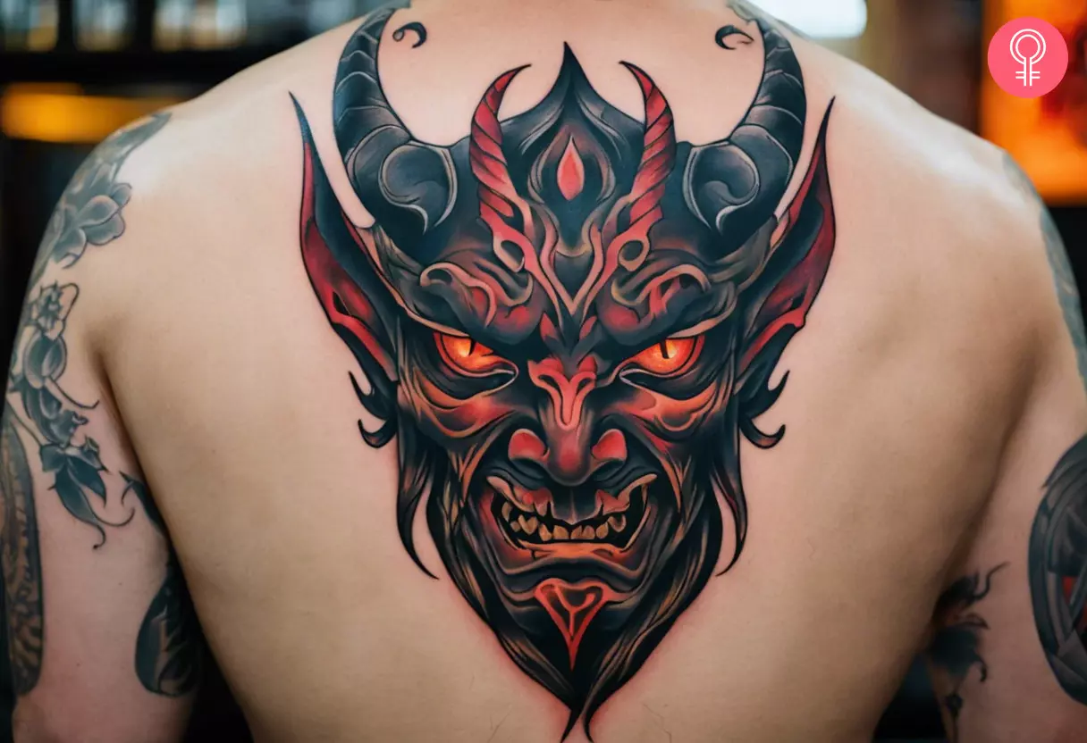 Demon face tattoo on the back