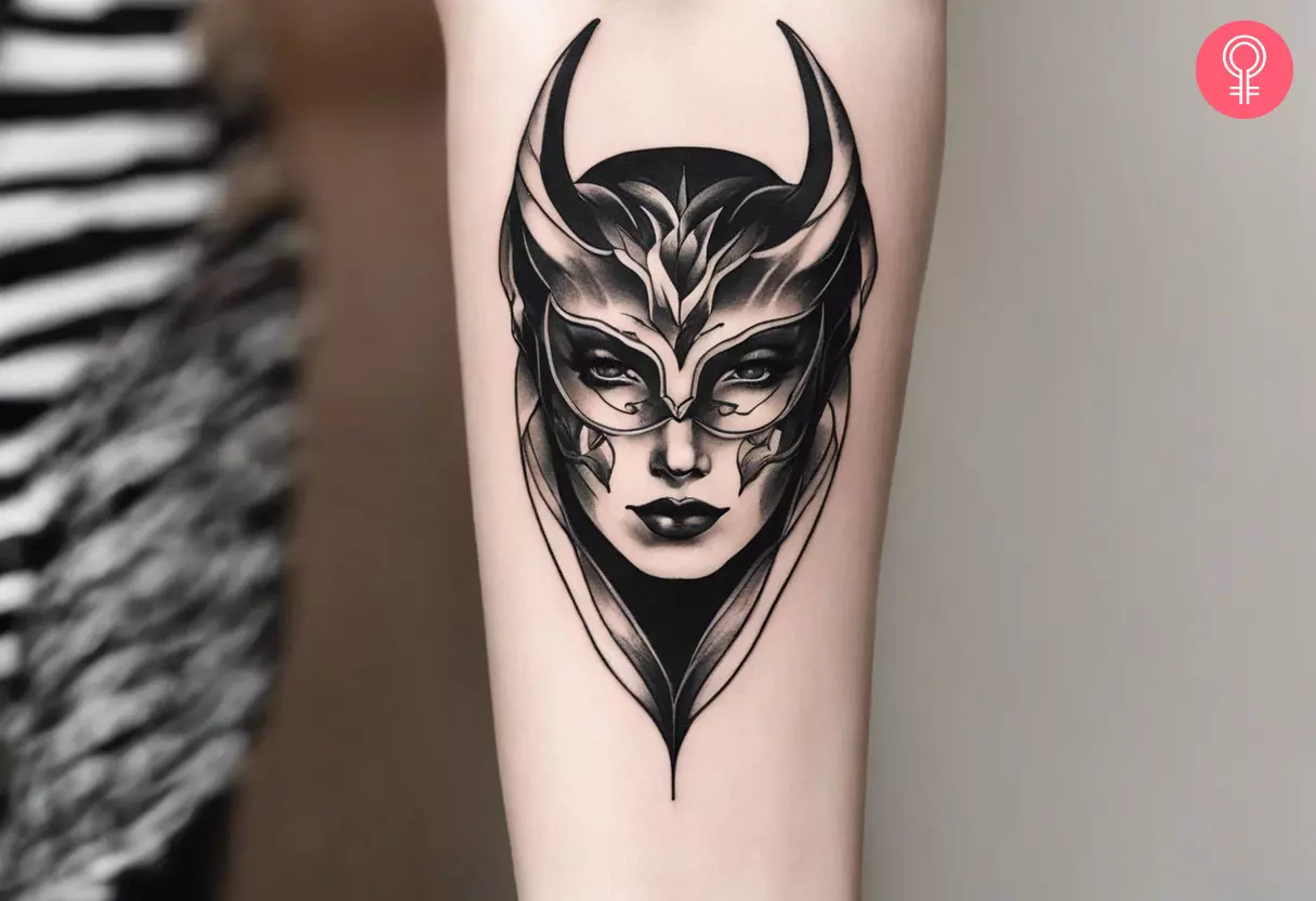 Demon mask tattoo on the forearm