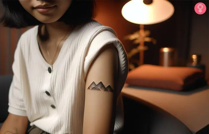 A woman with a family mountain tattoo on her upper arm