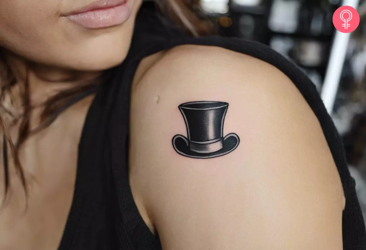 A fine line micro realism tattoo of a top hat