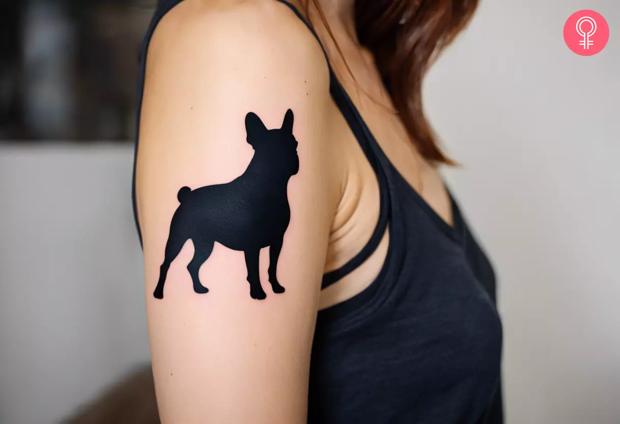 A silhouette style French bulldog tattoo on the upper arm