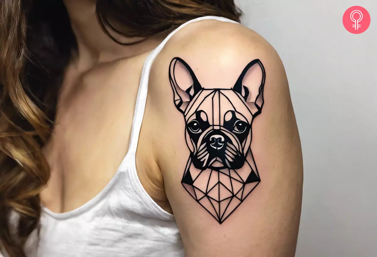 A geometric French bulldog tattoo on the upper arm of a woman