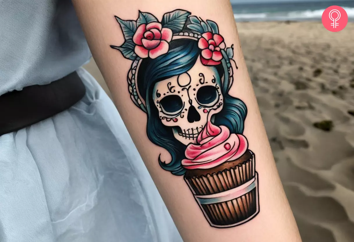 A woman flaunting a girly skull cupcake tattoo on her forearm