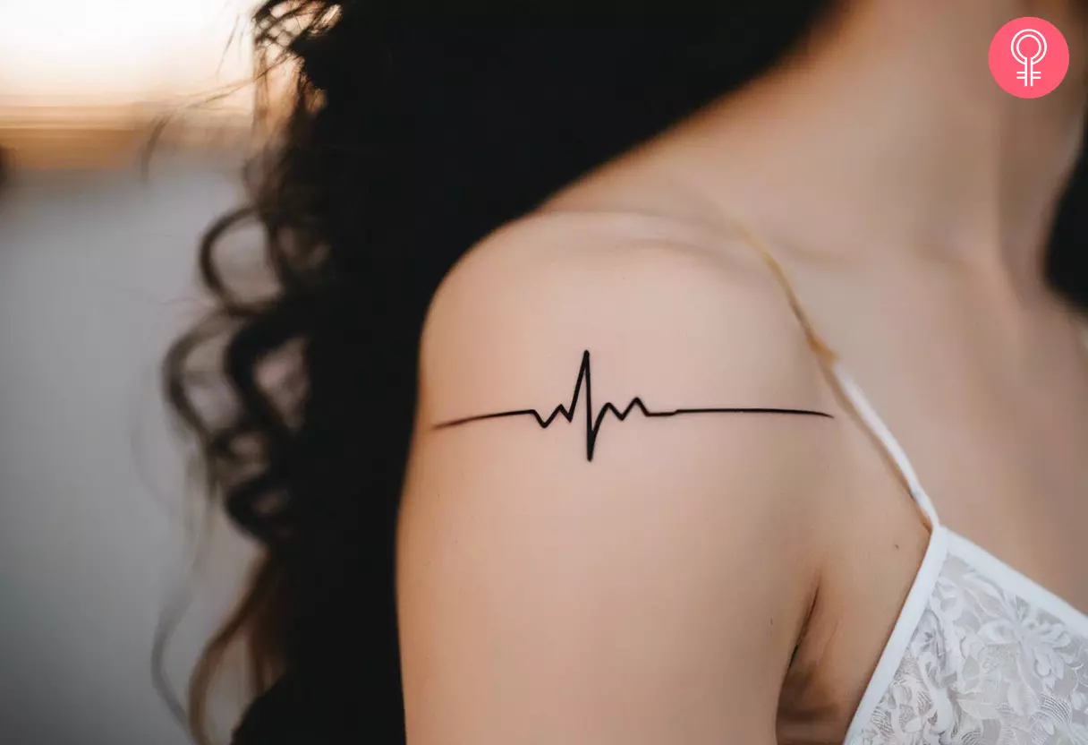 Heartbeat lifeline tattoo on the upper arm of a woman