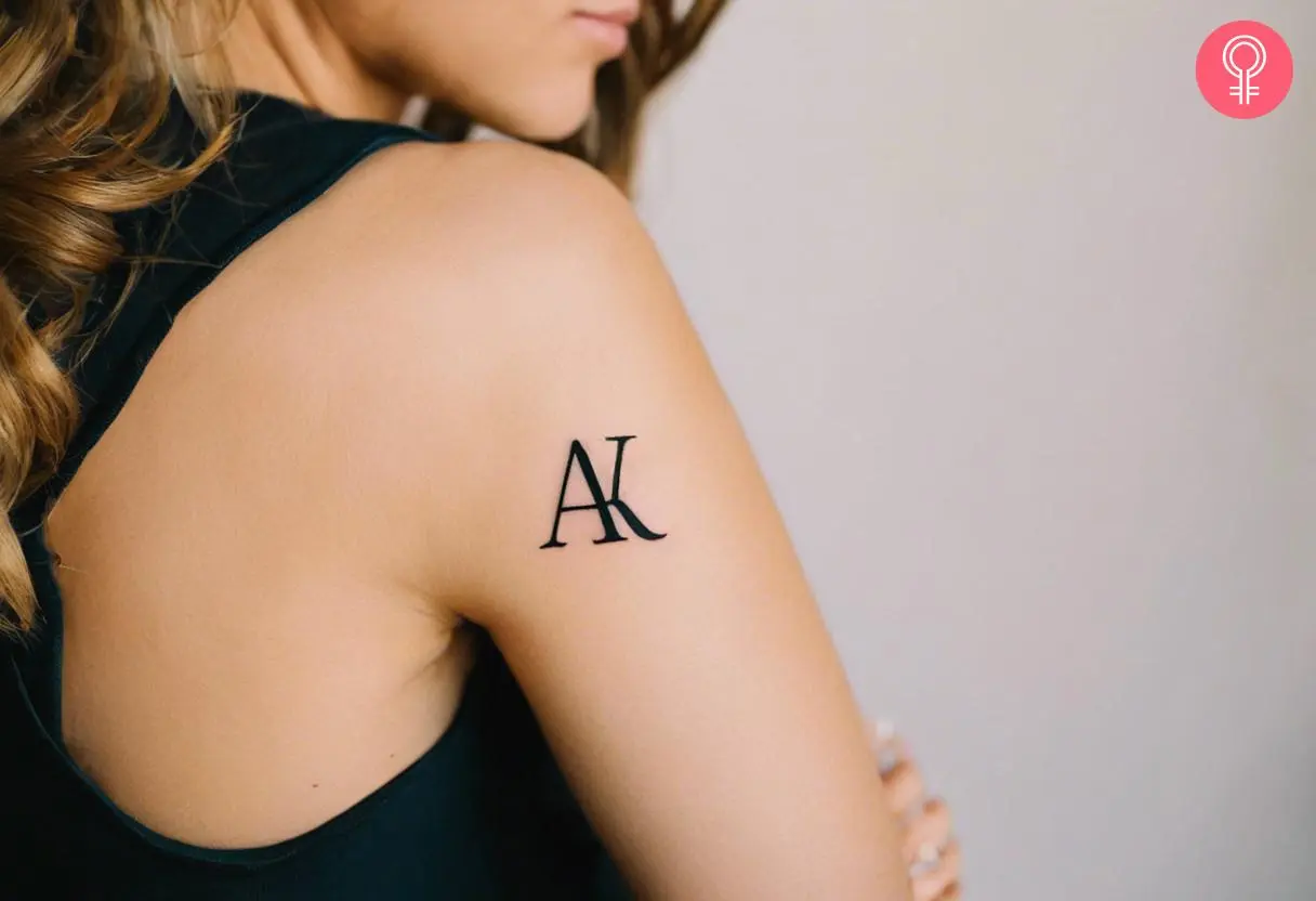 Woman with intertwined initial tattoo on her arm