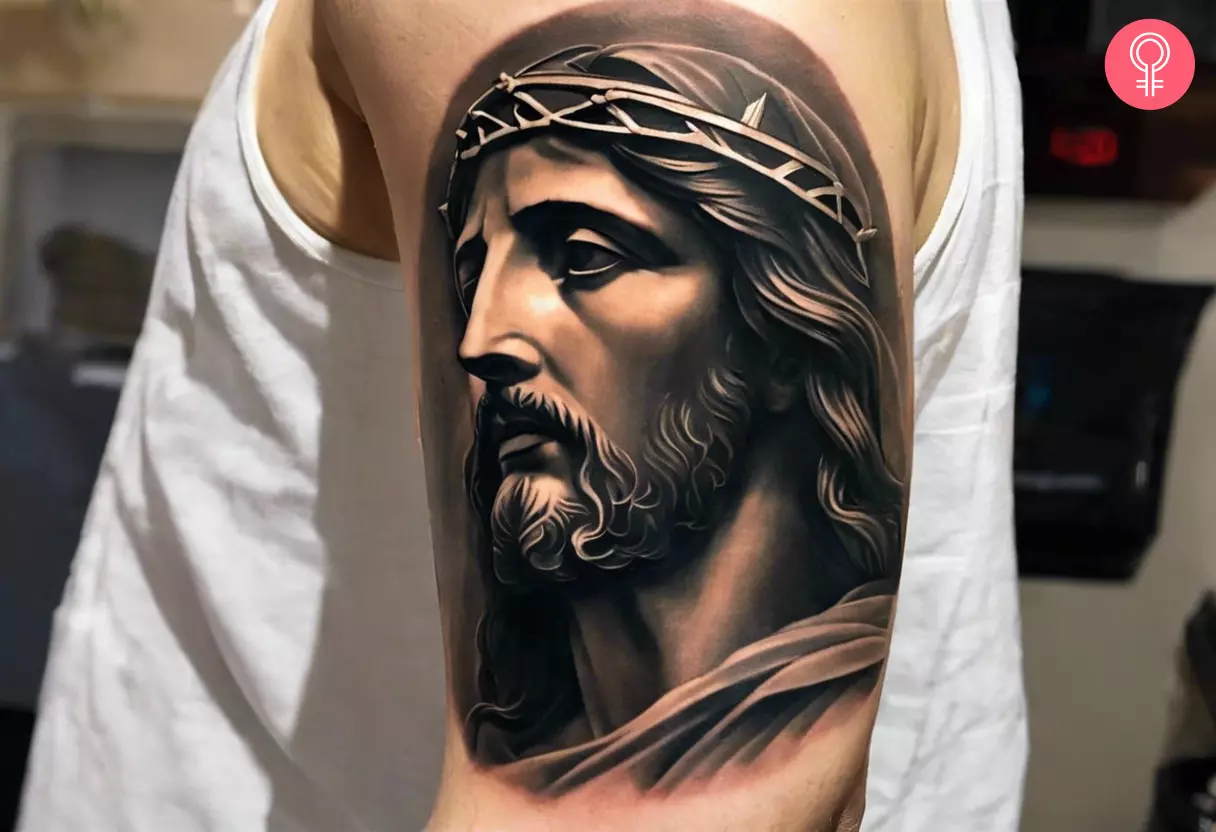 A man with a Jesus statue tattoo on the upper arm