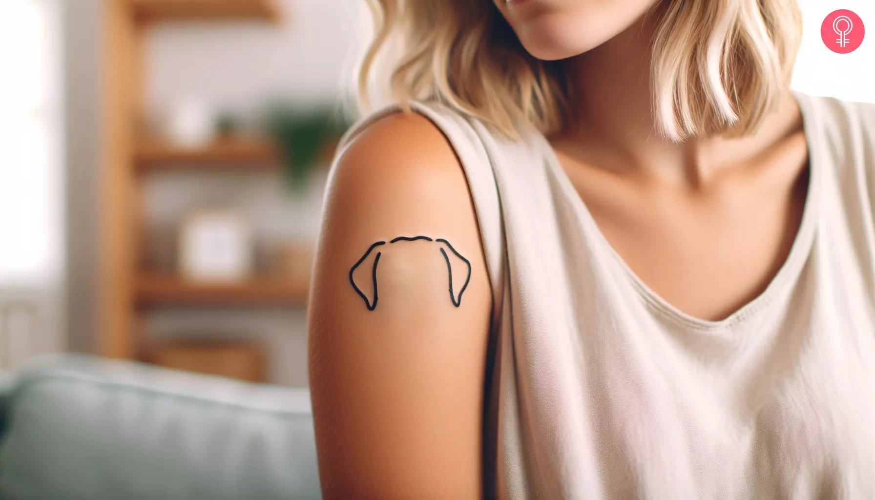 Woman showing off her Labrador ears tattoo on the upper arm