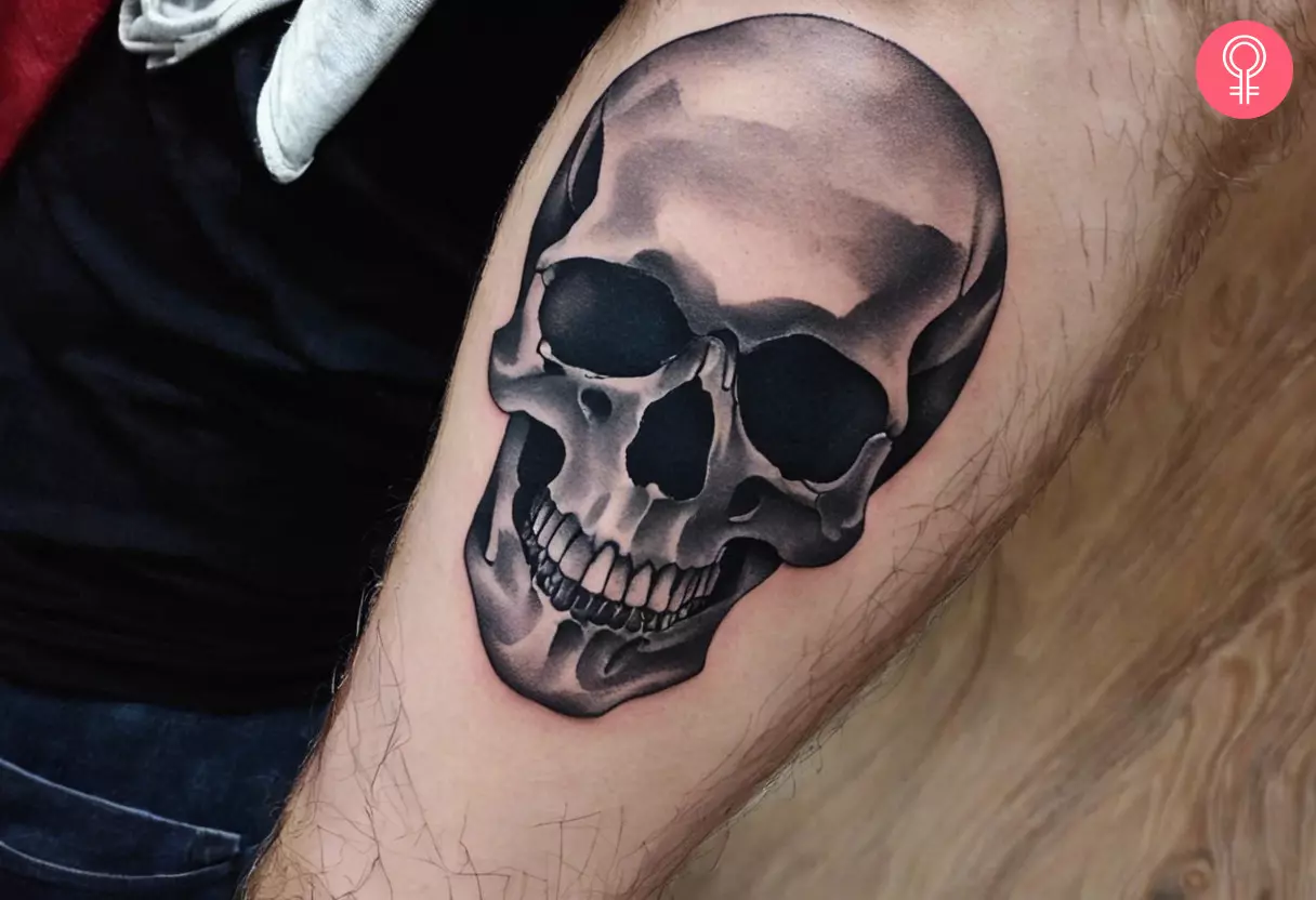 Man with black and gray skull tattoo on his forearm