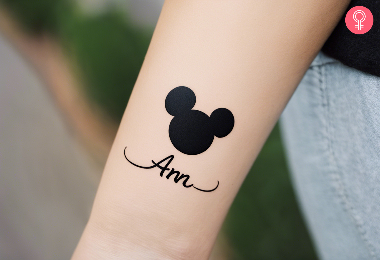 Mickey Mouse tattoo with name on the forearm