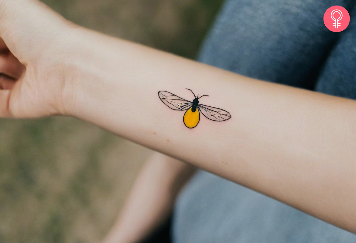 Woman with minimalist firefly tattoo on her forearm