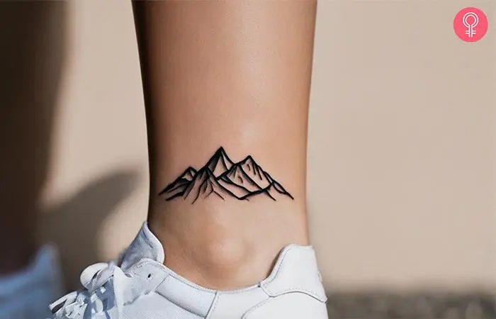 A woman with a mountain tattoo on her ankle