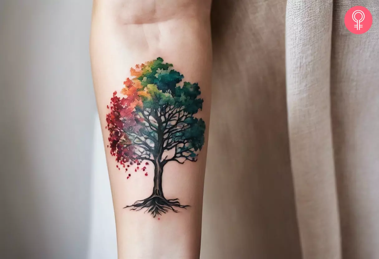 A woman with a watercolor oak tree tattoo on her forearm