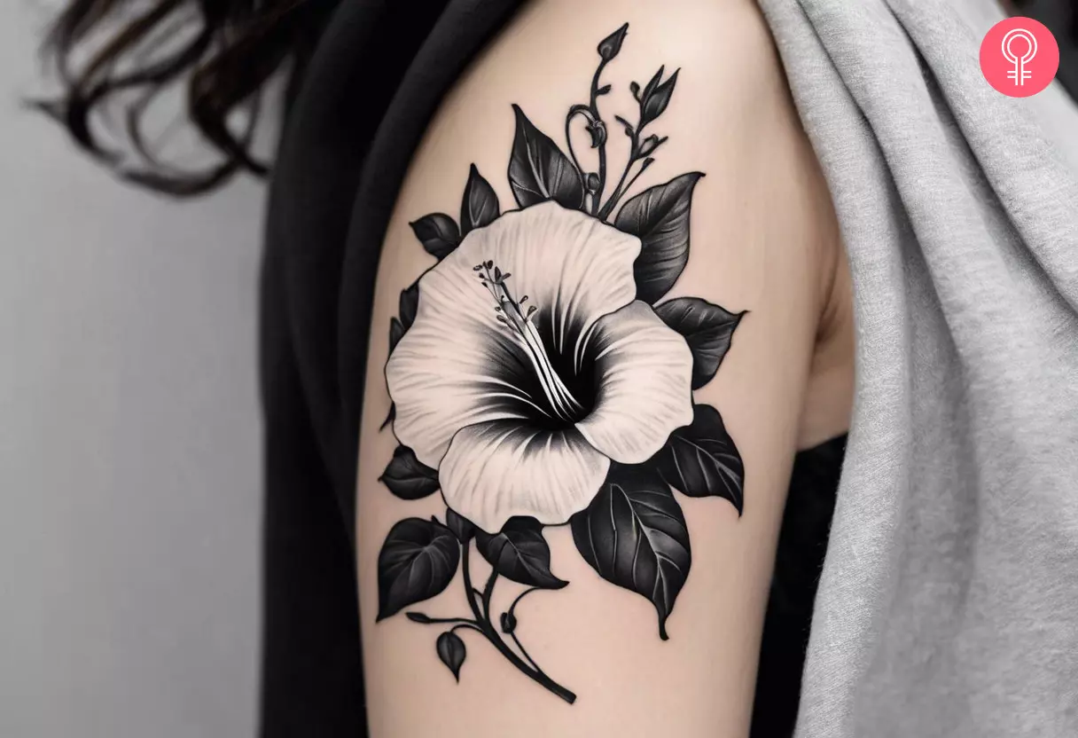 Black and white aster birth flower tattoo on the upper arm of a woman