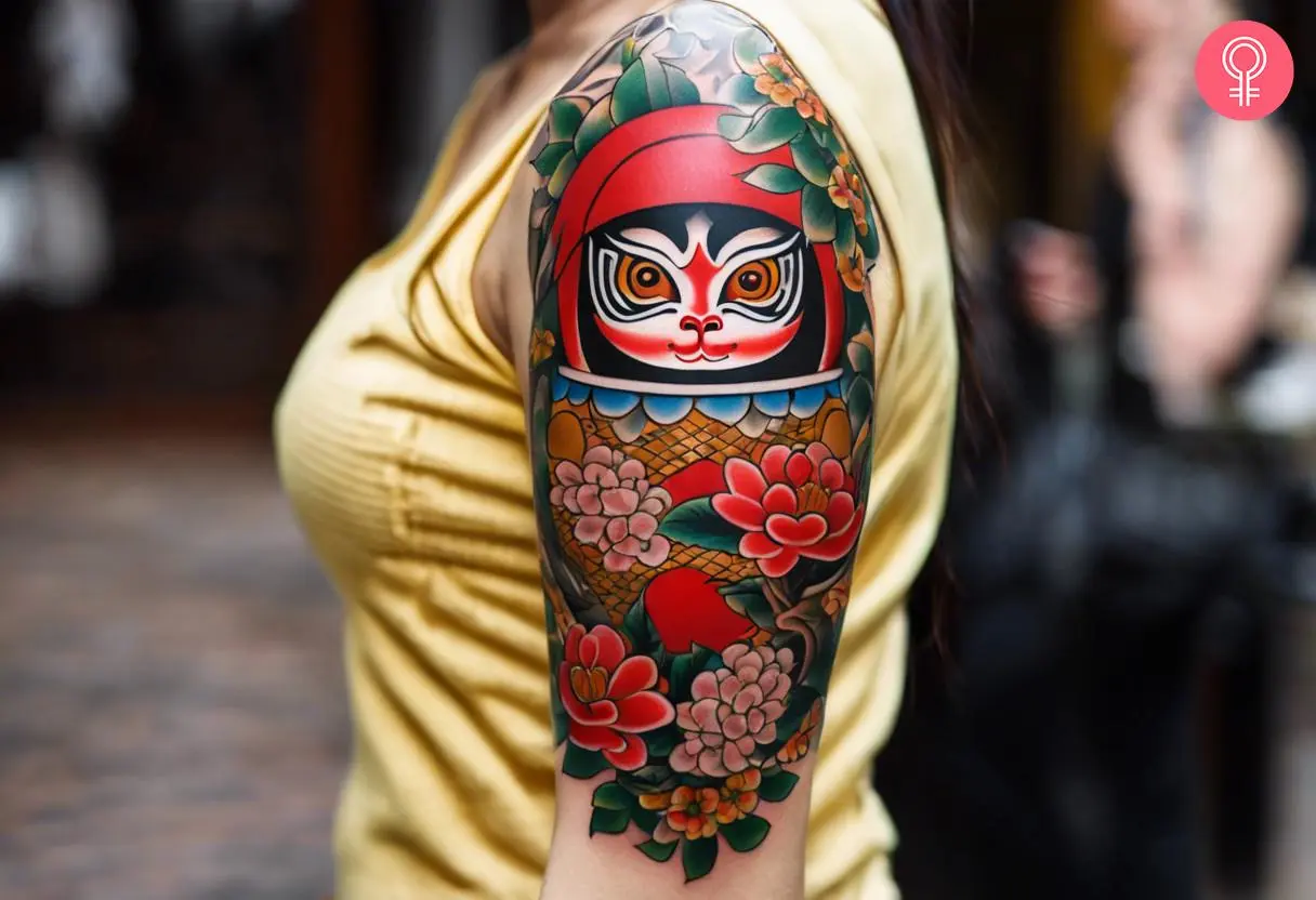 Sleeve tattoo of a Daruma doll on a woman’s arm