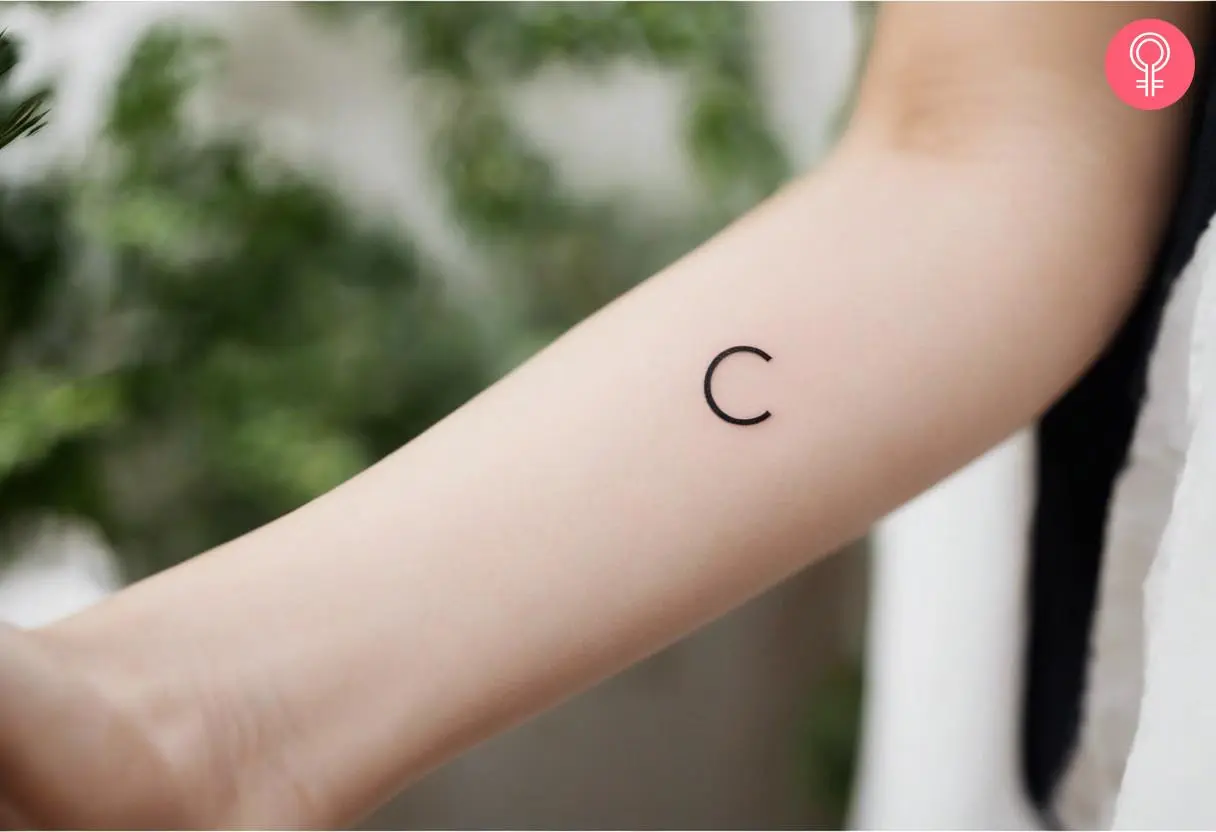 Woman with small initial tattoo on her forearm