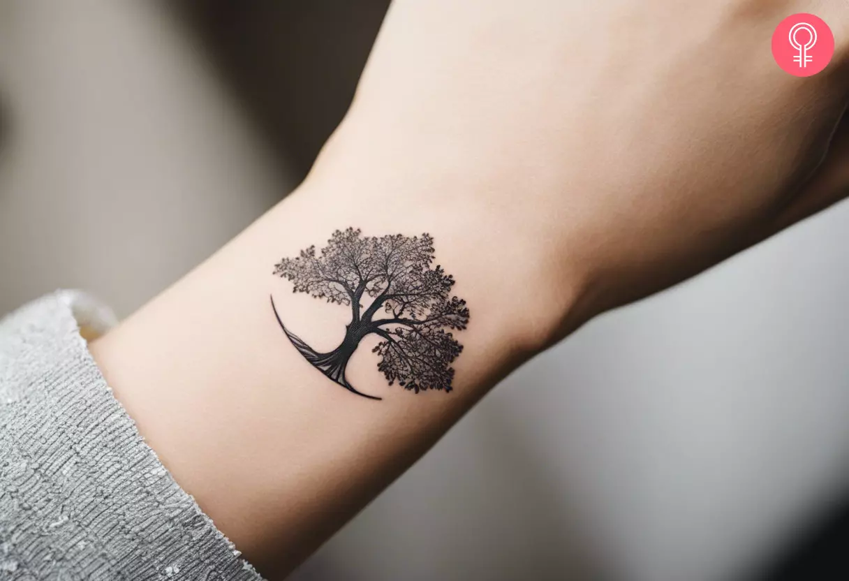 A woman with a small, minimalistic oak tree tattoo on her lower arm