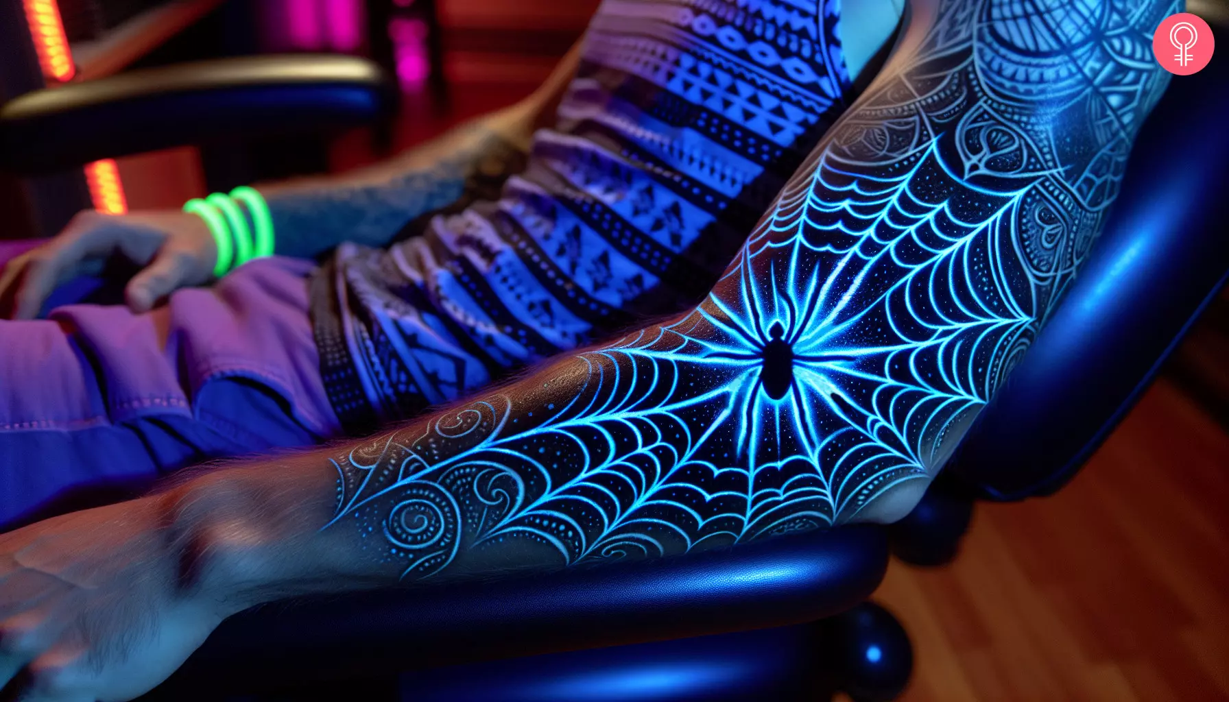 A spider web UV light tattoo on the arm of a man