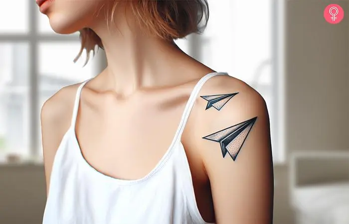 Atattoo of two flying paper airplanes on a woman’s arm