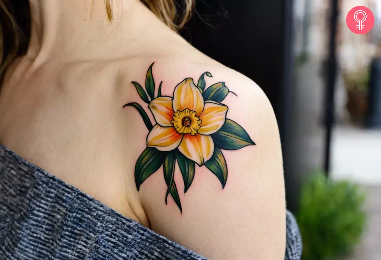 Woman showing off a narcissus tattoo on her shoulder