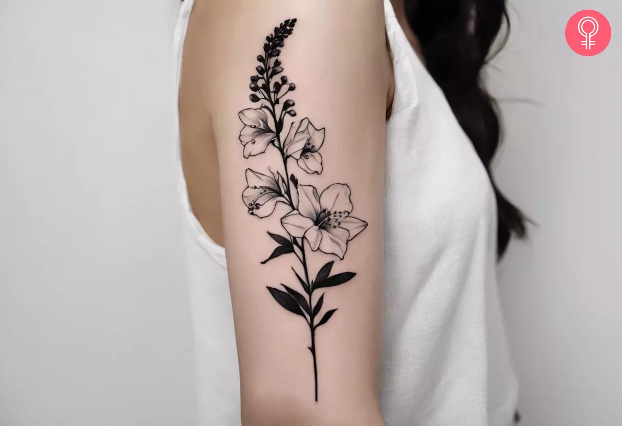 Woman with a delphinium black and white tattoo on the upper arm