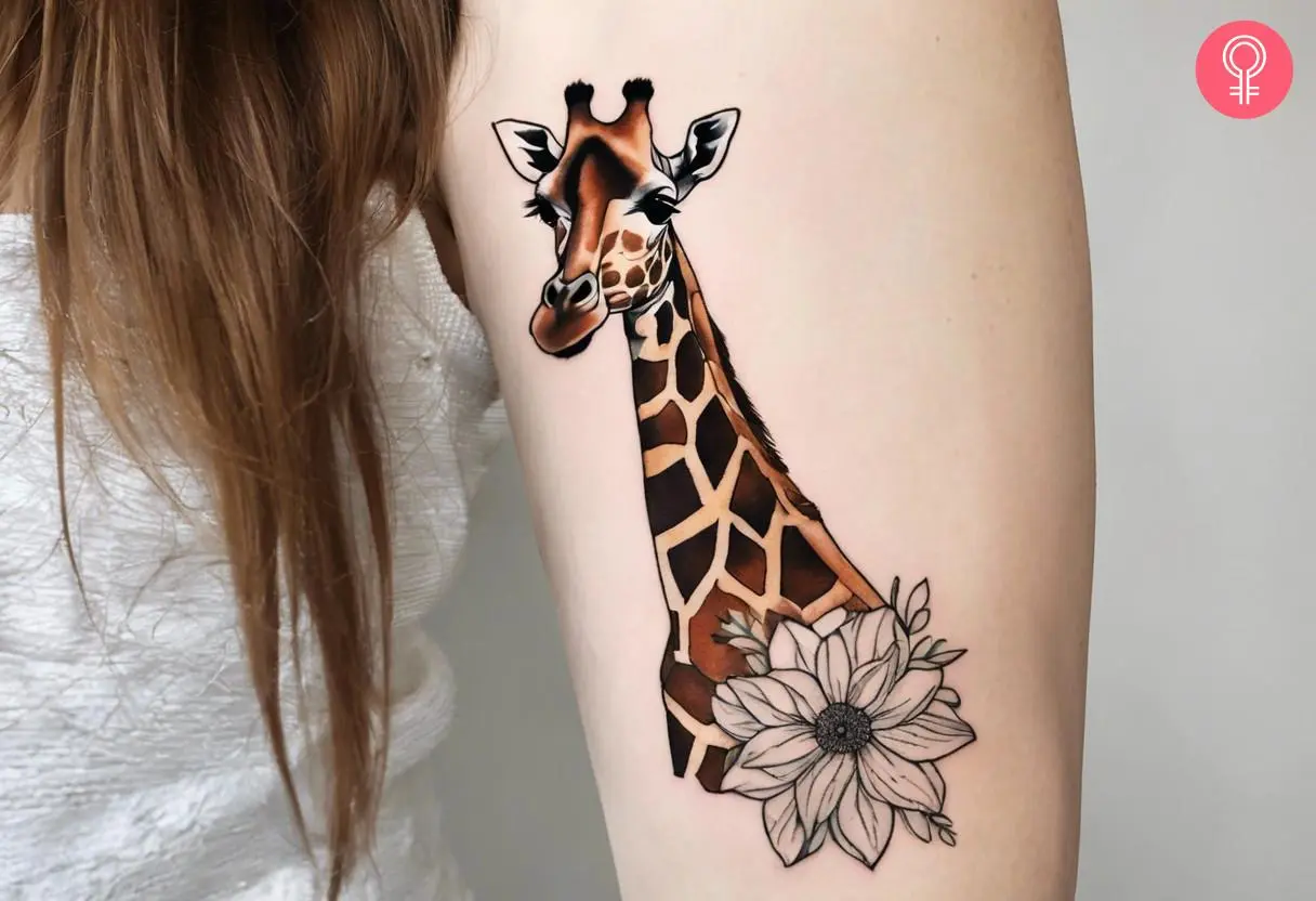 Woman with a giraffe tattoo with flowers on the upper arm