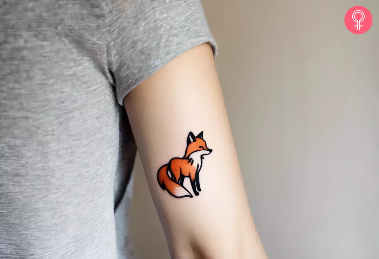Woman with a small fox tattoo on the upper arm