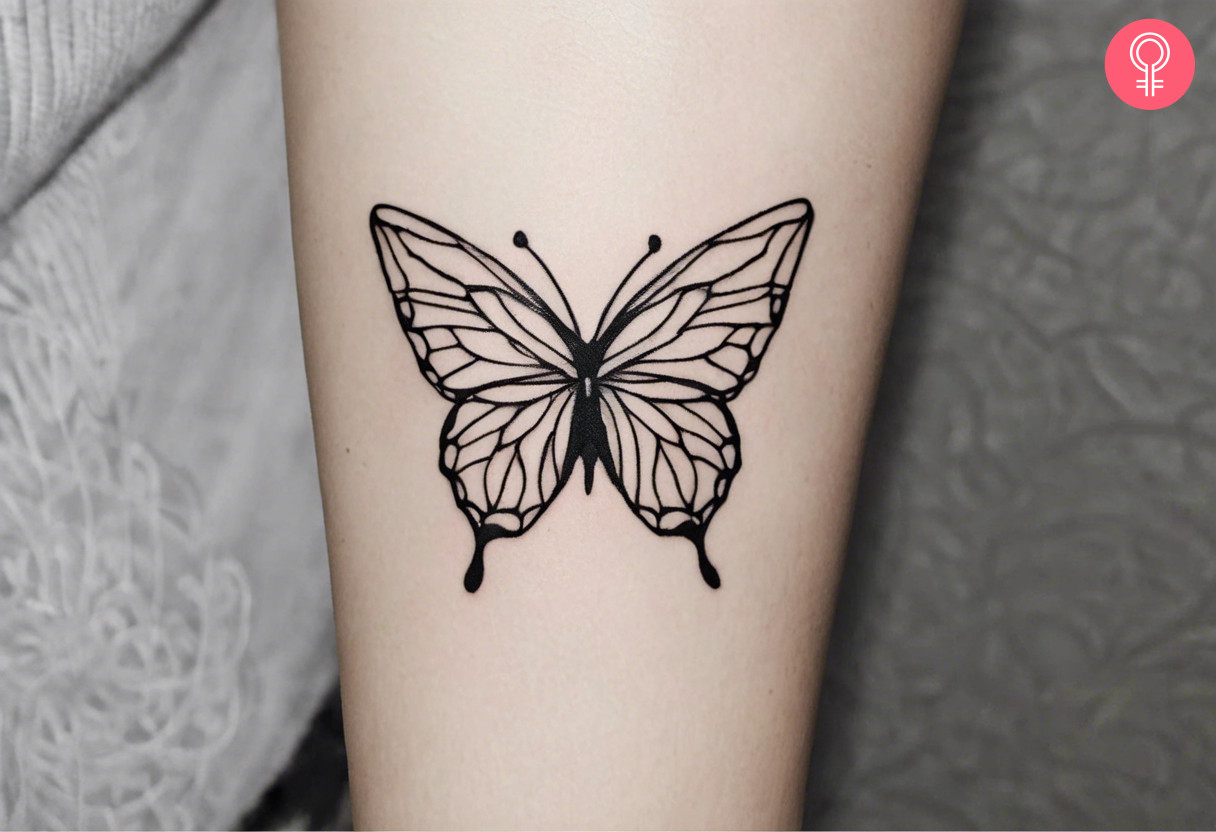 Woman with minimalist butterfly outline tattoo on her forearm