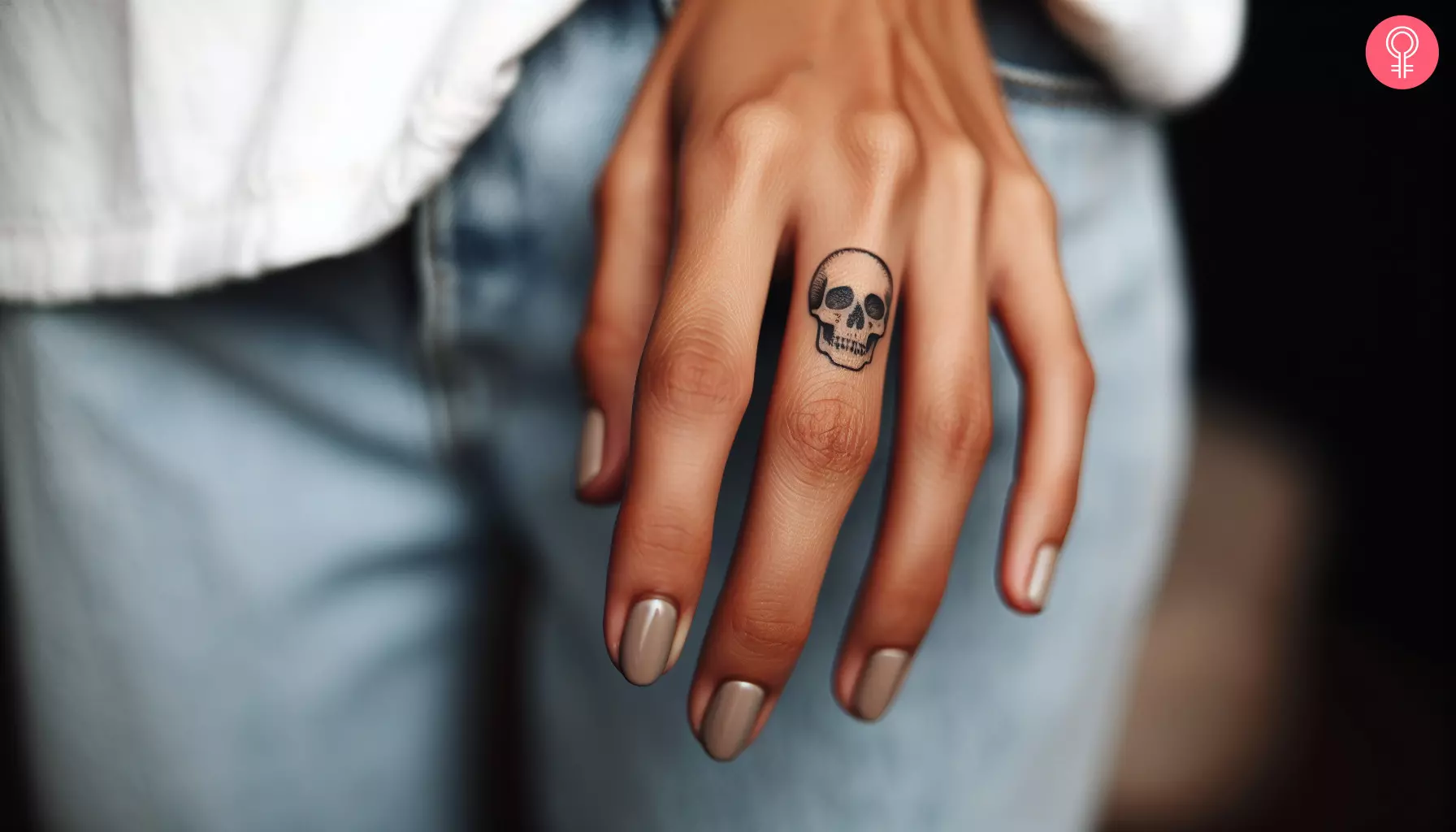 Woman with minimalist skull tattoo on her finger