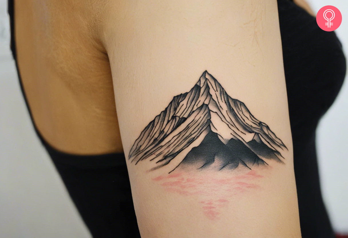 Woman with mountain outline tattoo on her outer arm