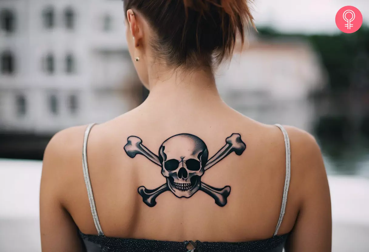 Woman with skull and crossbones tattoo on her upper back