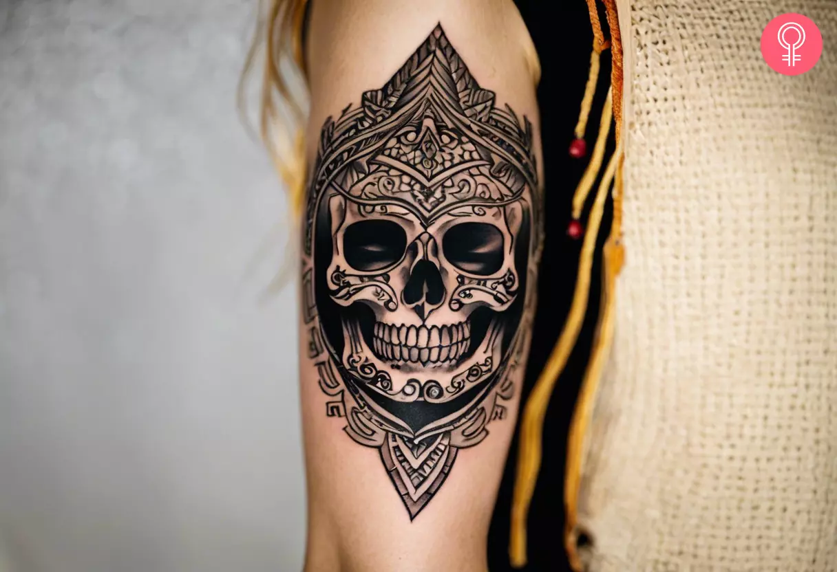 Woman with tribal skull tattoo on her outer arm