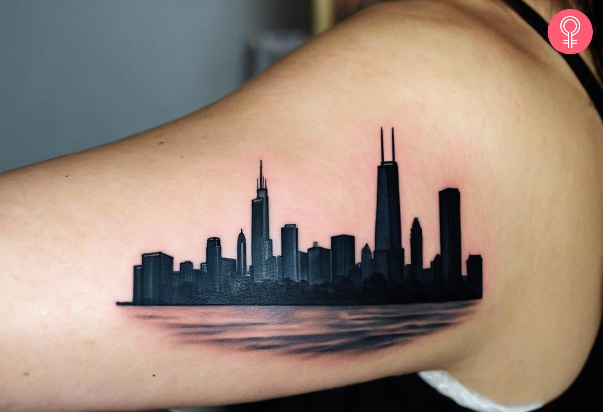 A 3D Chicago skyline tattoo on the upper arm of a woman