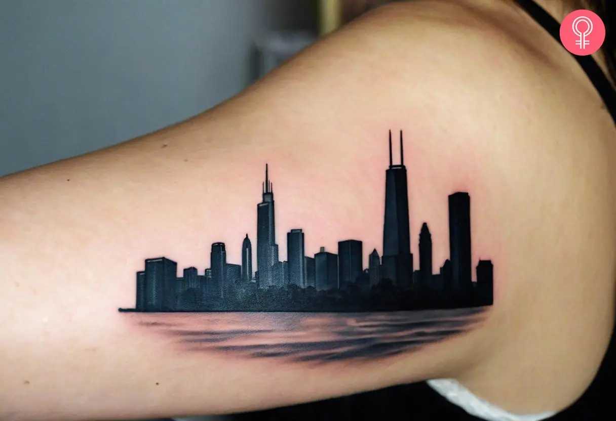 A 3D Chicago skyline tattoo on the upper arm of a woman